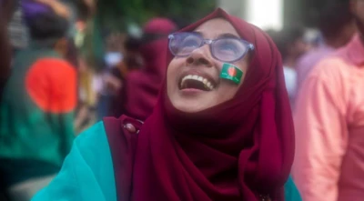 A Bangladeshi woman reacts on a street as people gather in Dhaka