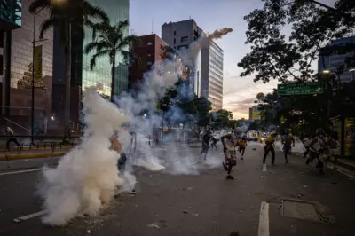 Rua em Caracas com manifestantes fugindo e lançando bomba de gás lacrimogêneo