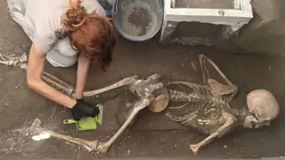 Uma cientista escavando os restos mortais encontrados em Pompeia.