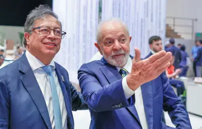 Presidente da Colômbia e Luiz Inácio Lula da Silva, lado a lado, com Lula fazendo sinal com a mão esquerda 