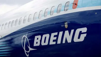 Nome da Boeing escrito em branco, estampado em um avião com fundo azul
