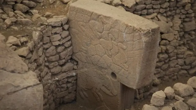 Coluna de Göbekli Tepe adornada com a imagem de um animal