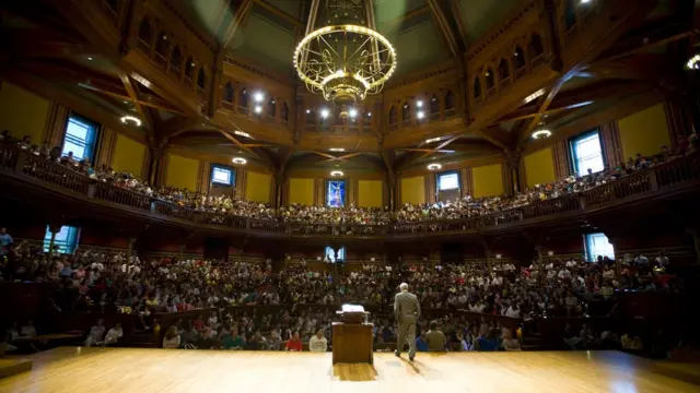 Michael Sandel dando palestras para centenas de alunos em um teatro de Harvard