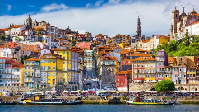 Imagem mostra imóveis e barcos na cidade do Porto, em Portugal