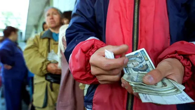 Ecuatorianos cambiando sucres por dólares en 2000.