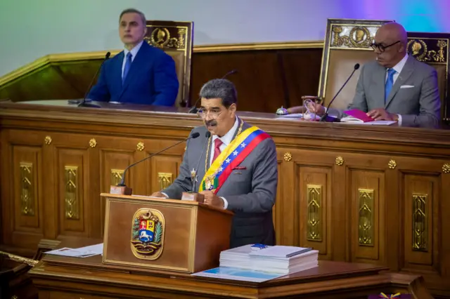 Nicolás Maduro no centro, discursando; o procurador-geral Tarek William Saab à esquerda; e Jorge Rodríguez, presidente da Assembleia Nacional, à direita