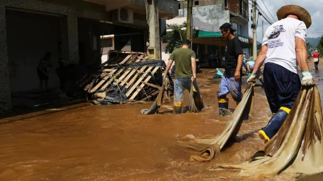 Pessoas limpando casas depois da chuva que alagou regiões inteiras na cidade de Roca Sales, no Rio Grande do Sul