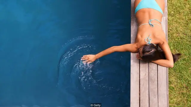 Mulher deitada na beira da piscina