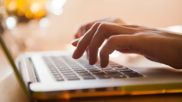 as mãos de uma pessoa digitando em um computador