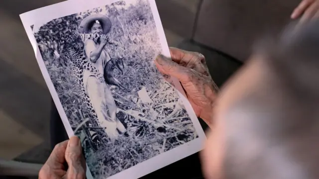 Homem segura foto mostrando caçador com onça e paca mortas