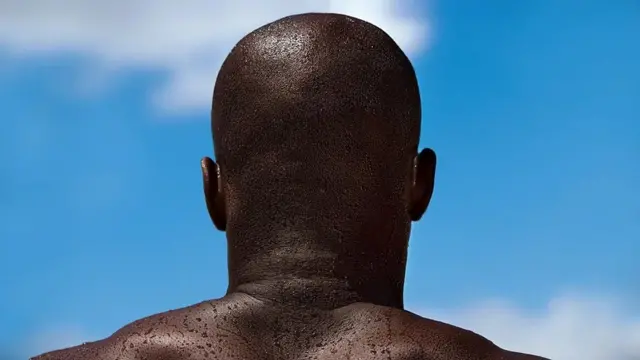 Homem negro e careca de costas olha para o céu azul