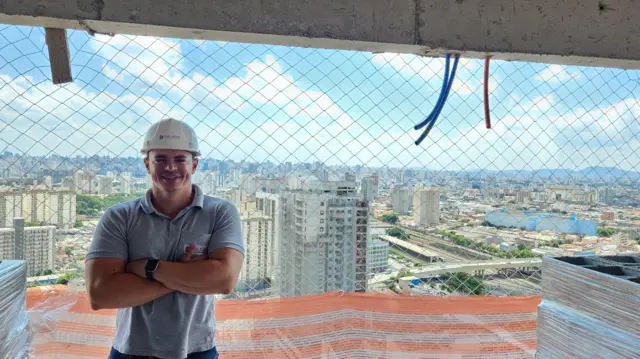 Denis Sousa de braços cruzados em prédio em construção no bairro da Mooca, na zona leste de São Paulo
