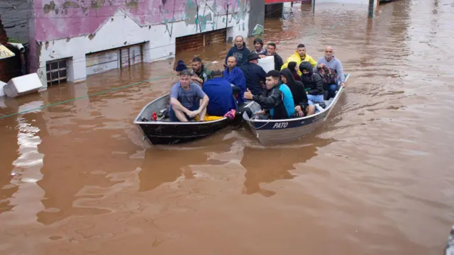 Imagem mostra dois barcos navegando em ruas alagadas em Porto Alegre