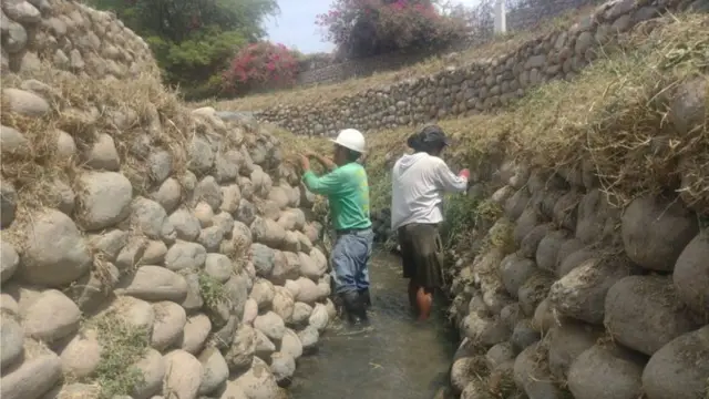 Pessoas trabalham na restauração de aqueduto na região de Nazca