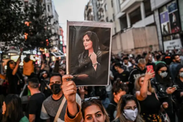 Em protesto, mulher levanta foto de Mahsa Amini