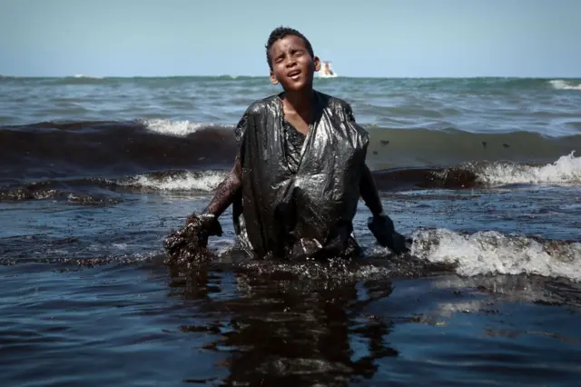 Um menino sai do mar na praia de Itapuama localizada na cidade de Cabo de Santo Agostinho, estado de Pernambuco, Brasil