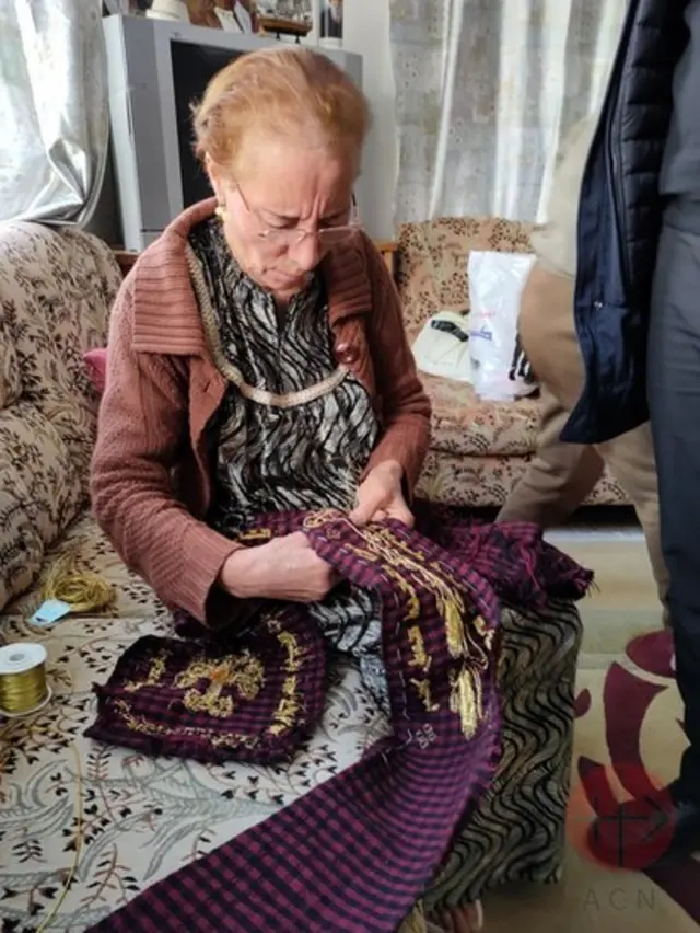 Mulher costurando estola que será usada pelo papa Francisco na Igreja Al-Tahira