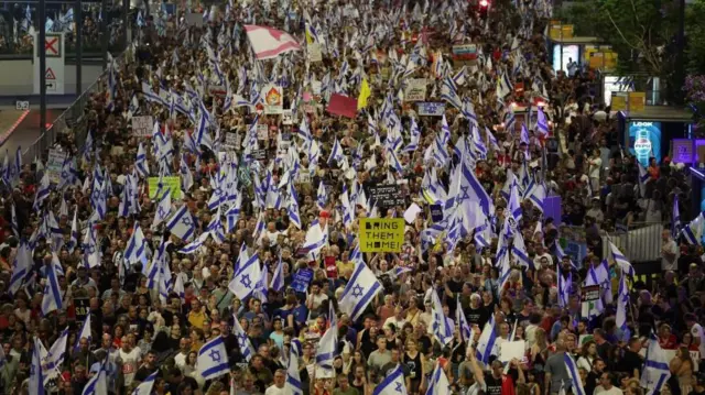 Pessoas que apelam ao gabinete de guerra israelita para assinar um acordo de reféns participam numa manifestação de protesto em frente ao quartel-general militar de Kirya, em Tel Aviv, Israel, em 15 de junho de 2024.