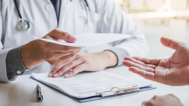 Médico entregando receita médica para paciente