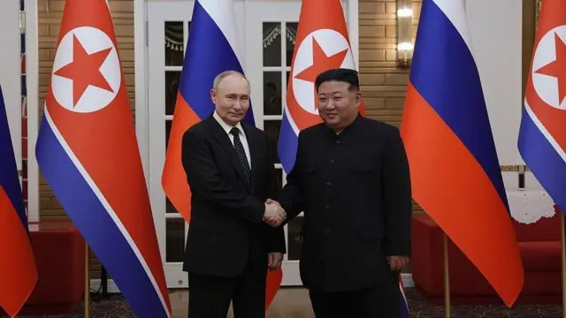 Aperto de mãos de Vladimir Putin e Kim Jong Un na Coreia do Norte com bandeiras ao fundo