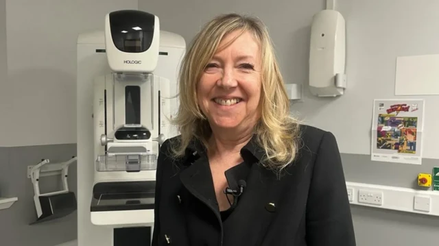 Sarah Kerruish sorrindo em frente a equipamento médico