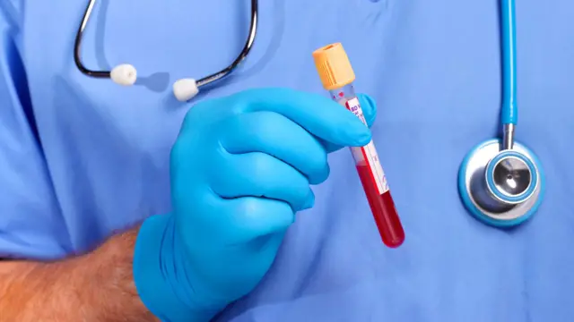 Enfermeiro com frasco de sangue na mão