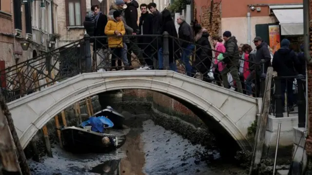 Turistas observam canal quase seco