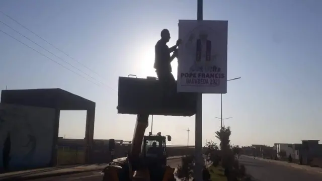 Homem pendura cartaz sobre checada do Papa Francisco