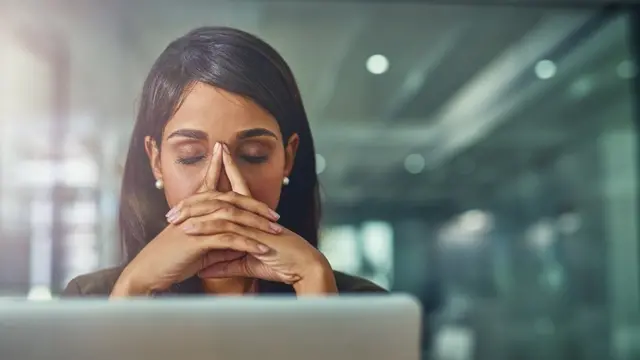 Mulher olha angustiada para o computador