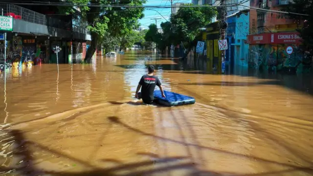 Homem no meio de rua inundada em Porto Alegre