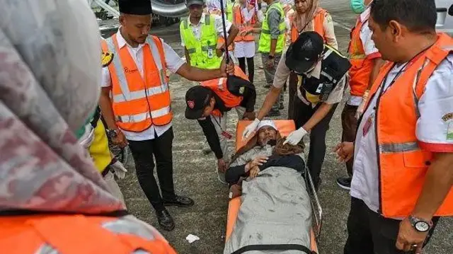 Um homem sendo colocado em uma maca enquanto a equipe médica observa