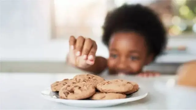 Menino e prato com cookies