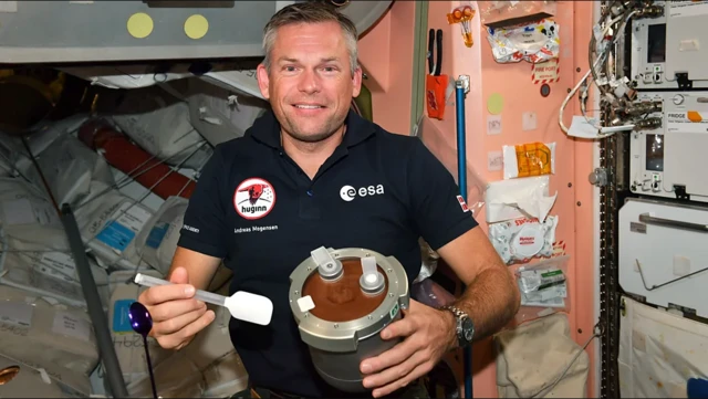 Astronauta Andreas Mogensen dentro de nave com pote cheio de apetrechos com mousse