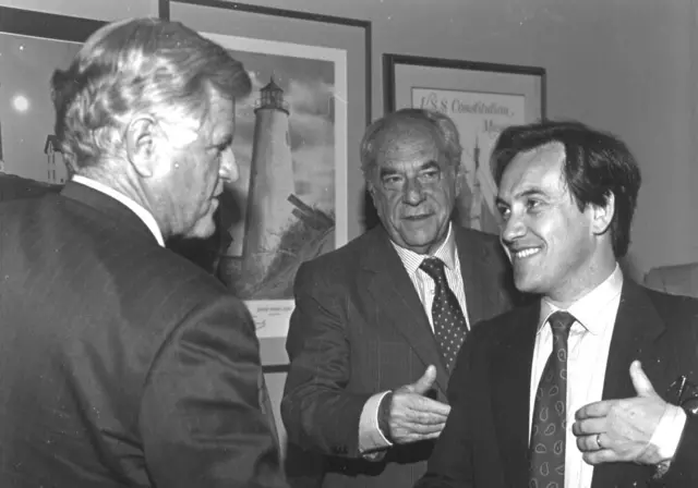 Sebastián Piñera sorrindo ao apertar a mão de Ted Kennedy; Gabriel Valdés aparece atrás 