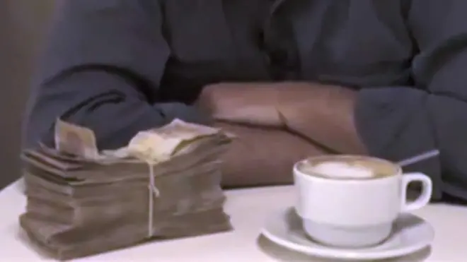 Maços de bolívares e uma xícara de café