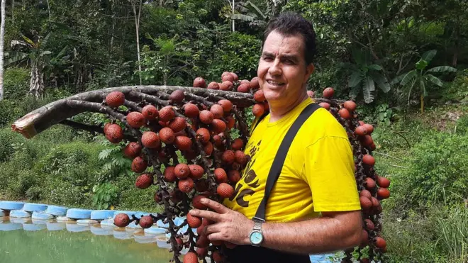 O botânico Valdely Kinupp segura um cacho de buriti, fruto típico da Amazônia e do Cerrado.