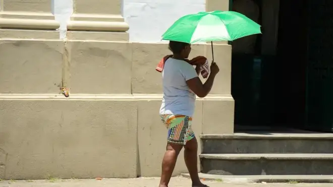 Mulher se protege do calor no Rio de Janeiro