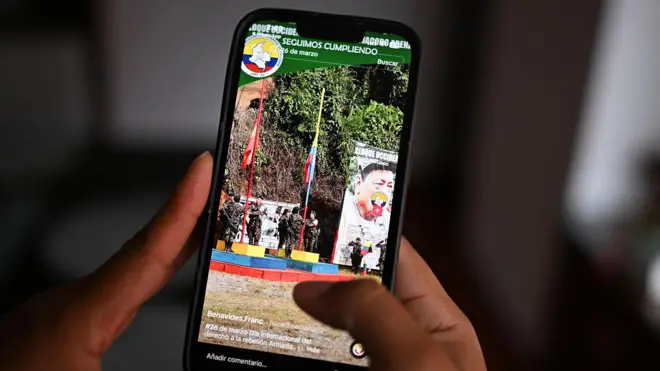Imagem de uma mão segurando um telefone celular mostrando uma conta de TikTok que promove um dos grupos armados dissidentes da Colômbia