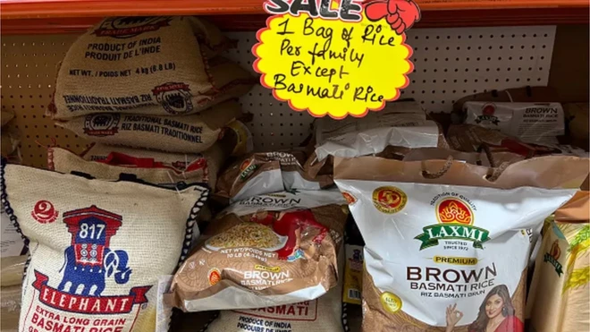 Pacotes de arroz à venda em mercado no Canadá, com placa indicando limite de venda de um pacote por família