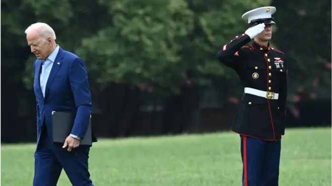 Biden walks past a Marine at the White House