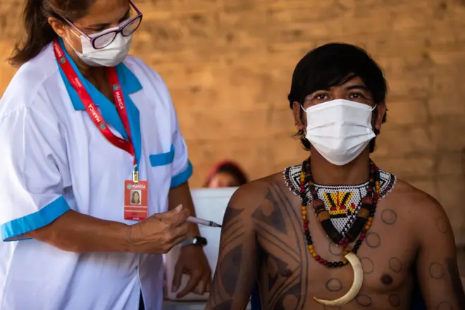 Indígena Guarani recebe vacina CoronaVac da enfermeira Rosane das Neves durante campanha de vacinação contra Covid-19 na Aldeia Mata Verde Bonita (Tekoa Ka'Aguy Ovy Porã) em 20 de janeiro de 2021 em Marica, Brasil.