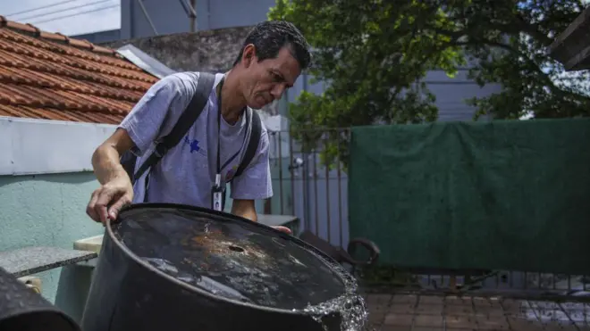 Agente de saúde retira água parada no quintal de casa em São Paulo