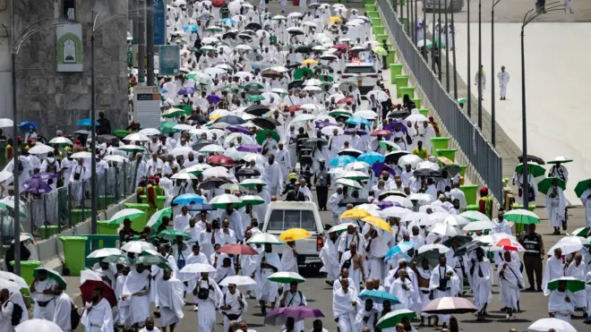 Pessoas chegando ao acampamento Mina de guarda-chuva