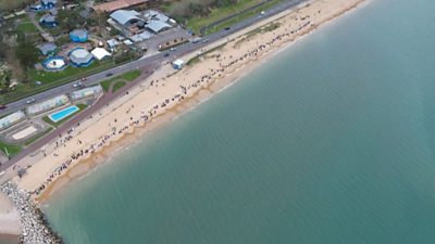 The line of about 300 people holding hands stretched along the beach in Weymouth.