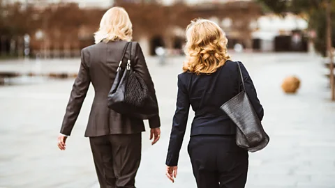 Two women talking while walking out of office