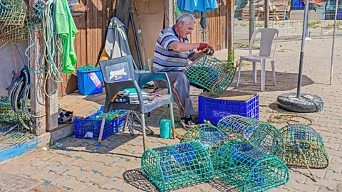 Local fisherman mending octopus traps in the Algarve, Portugal (Credit: Alamy)