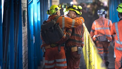 Two men in a coal mine, one with his arm around the other (Credit: Getty Images)