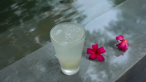 Glass of lemonade with two red flowers (Credit: Menty Jamir)