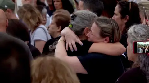 Two people hug at an event remembering victims of Hamas's 7 October attack on Israel