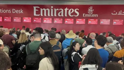 Reuters People queue at the flight connection desk the day after a storm swept across the UAE, causing flooding